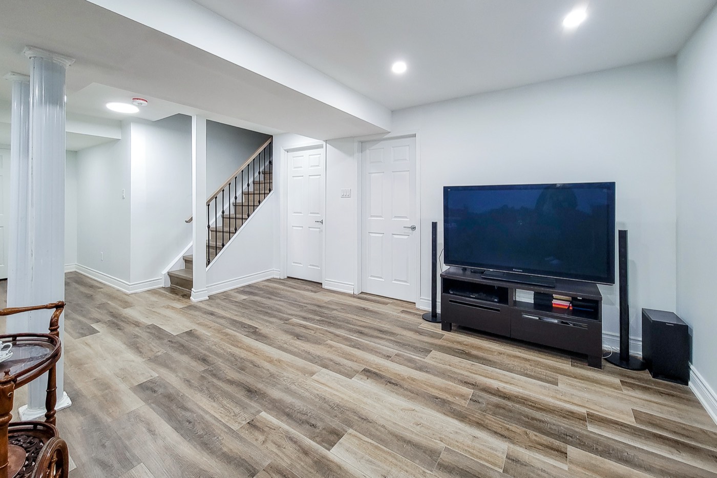 Cleaned basement media room with wood-look floors